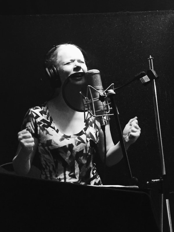 Tamara with a passionate look on her face singing into a microphone
