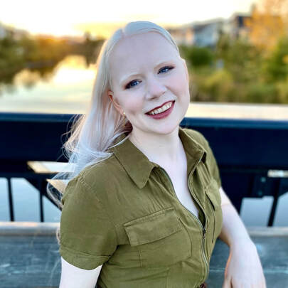 Tamara smiling at the camera at sunset on a bridge